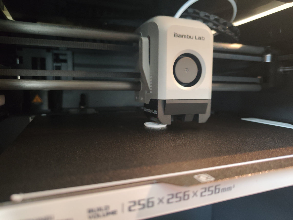 A close-up shot of a Bambu Lab 3D printer's print head printing